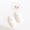 Protectores solares Montibello Sunage SPF 50 fluidos y con color Dos protectores solares Montibello Sunage SPF 50, fluido y con color, sobre fondo blanco. Muestras de crema beige en placa de Petri y gotas de producto blanco.